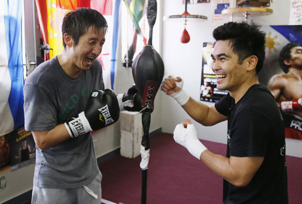 Two-time Olympic gold medalist and three-time world amateur boxing champion Zou Shiming (L) of China works out at Wild Card Boxing Club for his upcoming professional boxing debut as he poses for a photo with flyweight champion Brian Viloria (R) of the US, in Los Angeles, March 20, 2013.