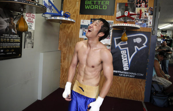 Boxer Zou Shiming of China laughs as he finishes training for his upcoming bout against Jesus Ortega of Mexico in Hollywood, California, July 11, 2013.