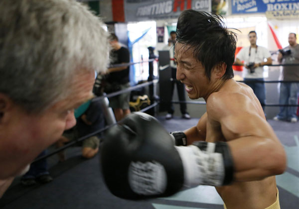 Boxer Zou Shiming of China spars with trainer Freddie Roach for his upcoming bout against Jesus Ortega in Hollywood, California July 11, 2013.
