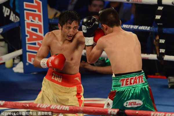 Zou Shiming, left, fights Mexico's Jesus Ortega during a six-round flyweight bout in Macao, China, July 27, 2013.