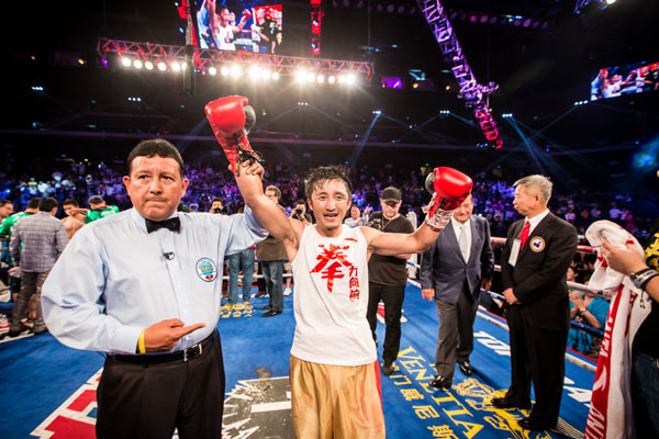 Zou Shiming, center, celebrates after defeating Mexico's Jesus Ortega in Macao, China, July 27, 2013.