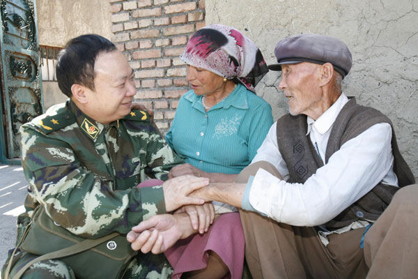 Zhuang Shihua talks with patients during a family visit in Urumqi, Xinjiang Uygur autonomous region, July 11, 2009. [Photo/Xinhua]
