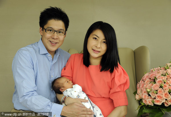 Guo Jingjing, right, Kenneth Fok Kai-kong and their new baby pose for a group photo at a news conference in Hong Kong, on Aug 29, 2013.