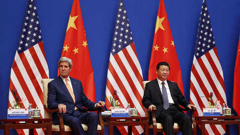 U.S. Secretary of State John Kerry and China's President Xi Jinping sit next to each other as they participate in a joint opening session of the U.S.-China Strategic and Economic Dialogue known as the 