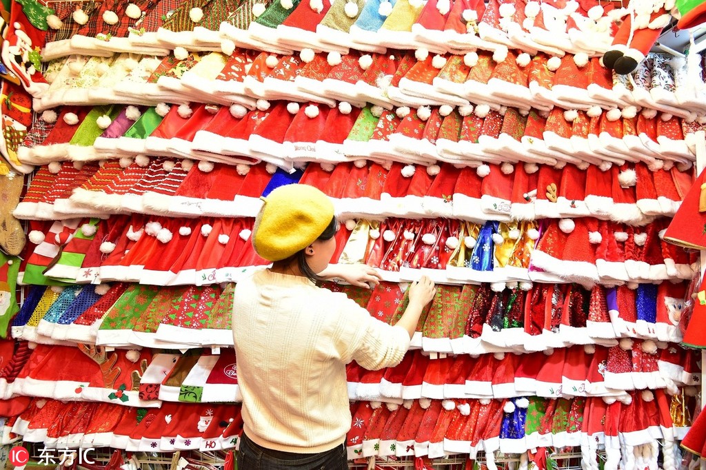 Shop keeper looking at hundreds of Santa hats | Yiwu International Trade City