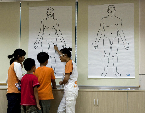 Gao Weiwei (right), a lecturer, talks to students about the human body at a summer camp focusing on sex education. The camp, believed to be the first of its kind in Shanghai, was established in 2009. Zhang Dong / for China Daily 