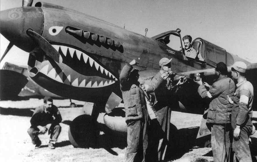 飞虎队不仅指飞行员，还包括地勤人员、机械维修师、办公室人员等。飞虎队地勤人员利用机头发动机散热器的侧面，描绘出硕大、张开的鲨鱼嘴。迪斯尼协会的罗伊·威廉斯还为飞虎队设计了一个队徽：一只插翅的猛虎。这是1942年，昆明机场，中国士兵和美国军械师对飞机进行检修。[Sina.com]