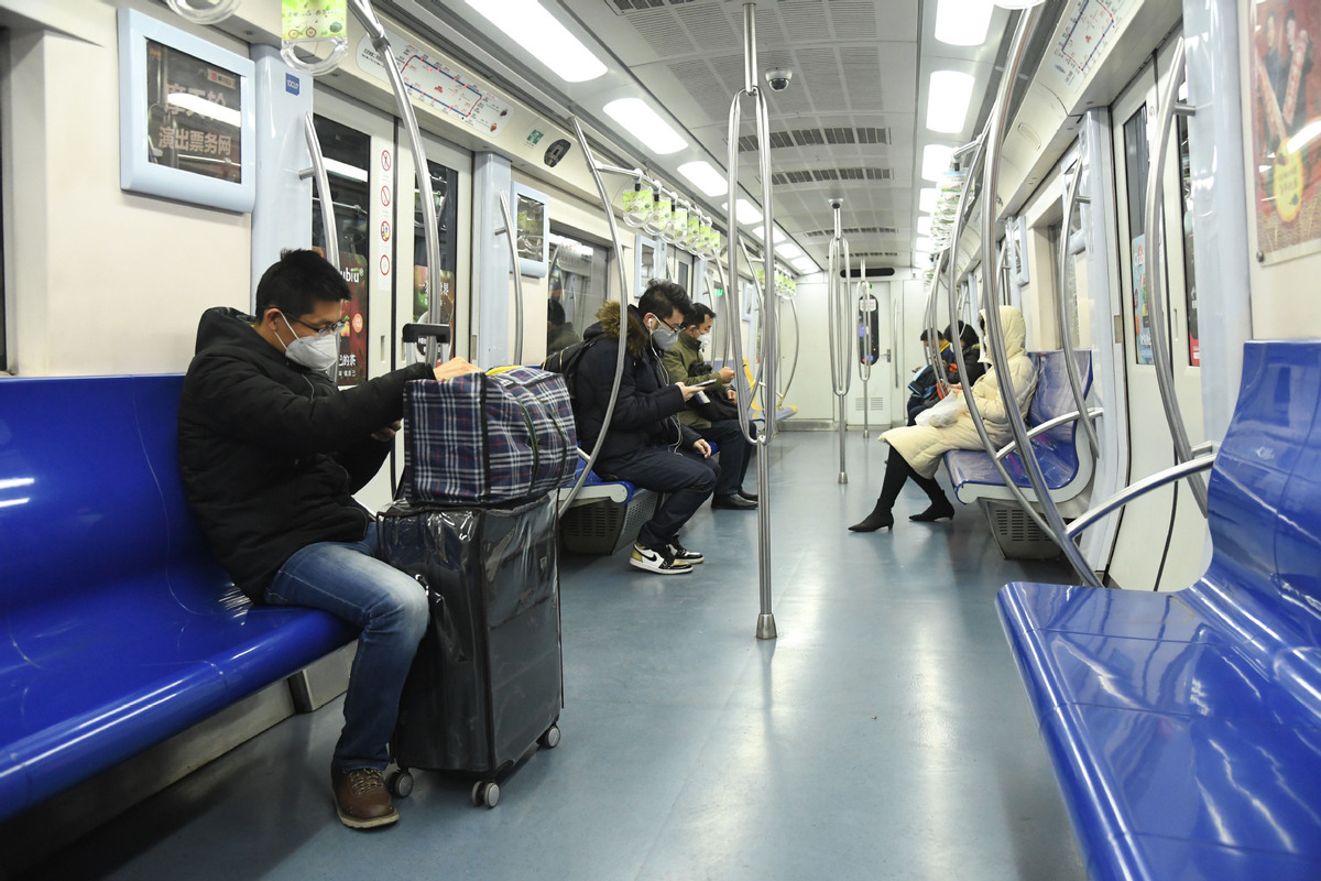 Students play online games inside a subway train in Beijing