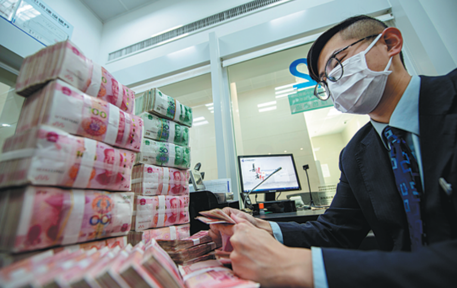 a bank clerk checks currency in haian, jiangsu province.