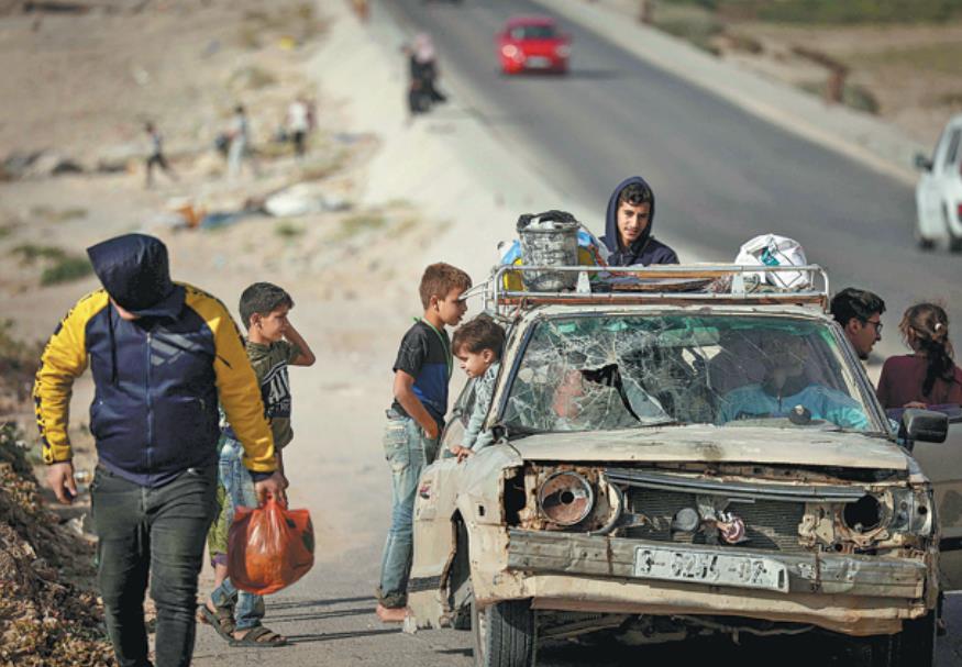 people in gaza city take a ride along the beach in a heavily