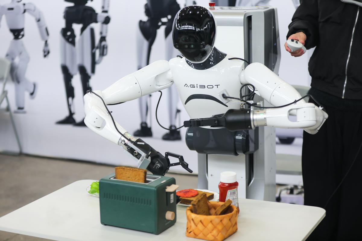 A robot developed by AgiBot, an artificial intelligence and robotics startup, makes toast at the 2025 Global Developer Conference in Shanghai on Feb 21. PROVIDED TO CHINA DAILY